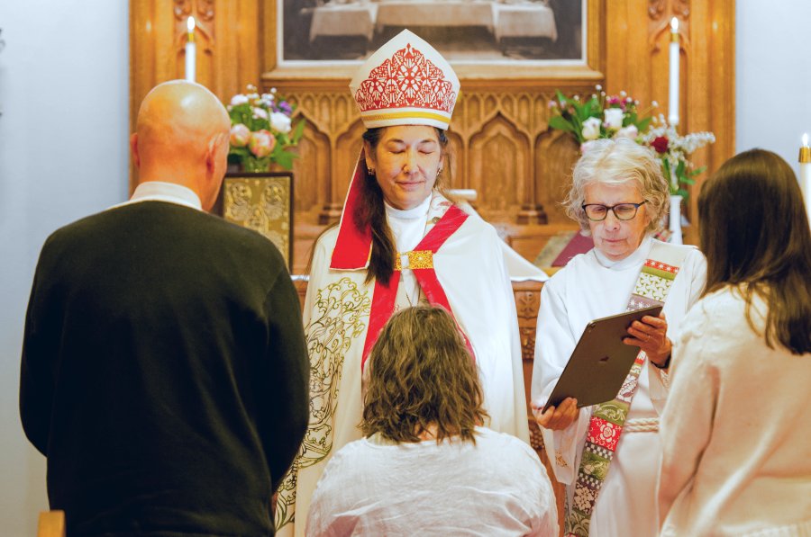 Bishop praying with parishioners at Good Sam