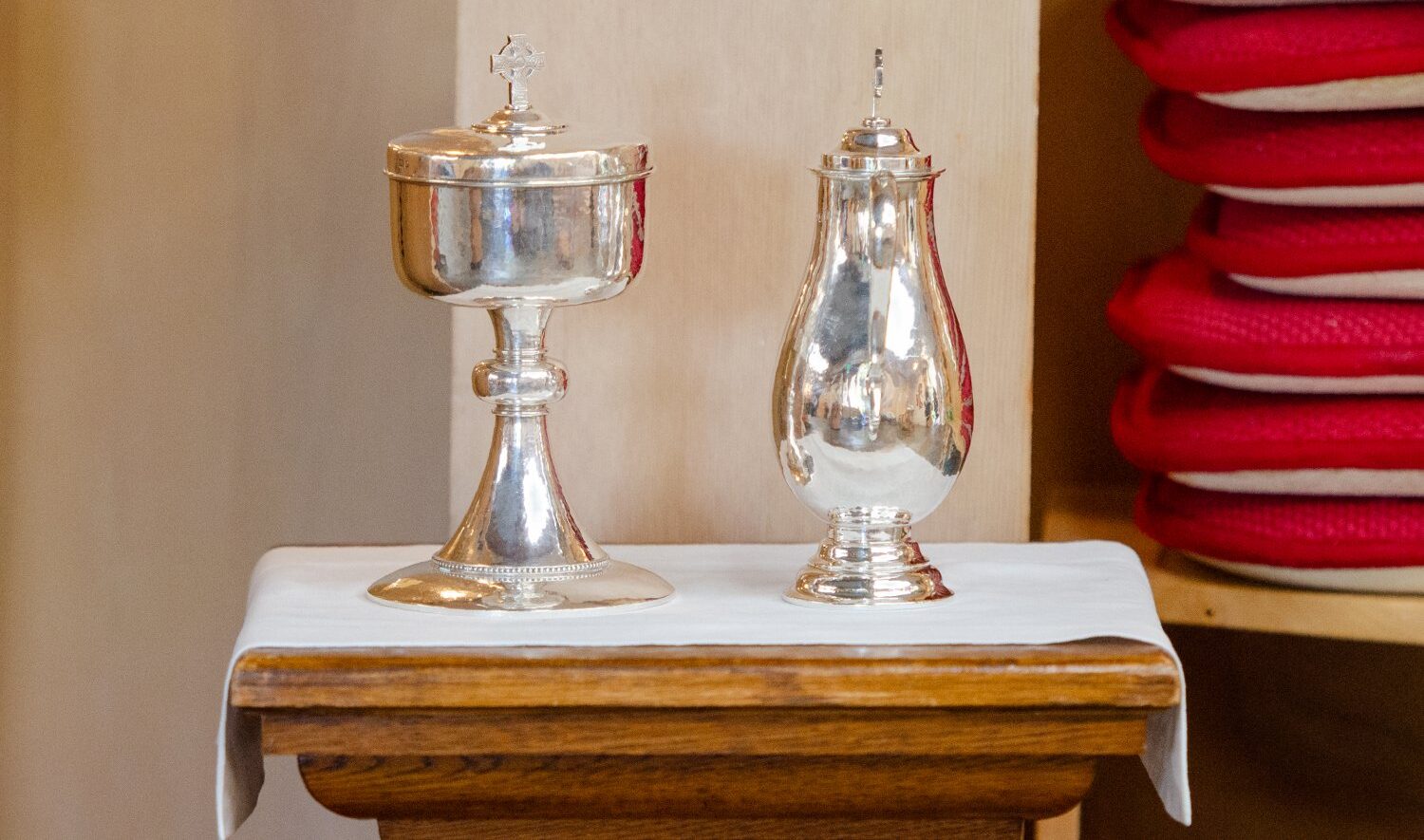 Silver vessels on a small table with a white cloth