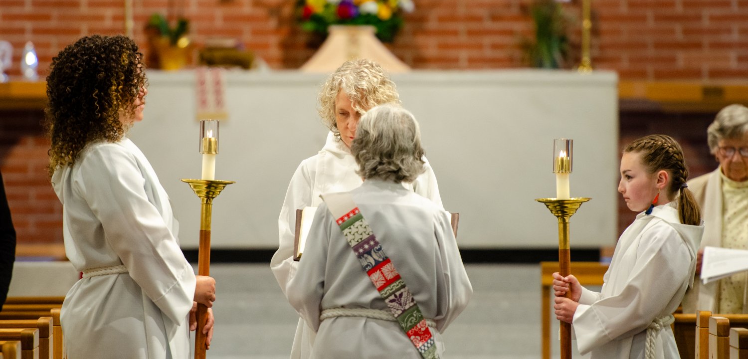 Acolytes holding candles in the sanctuary
