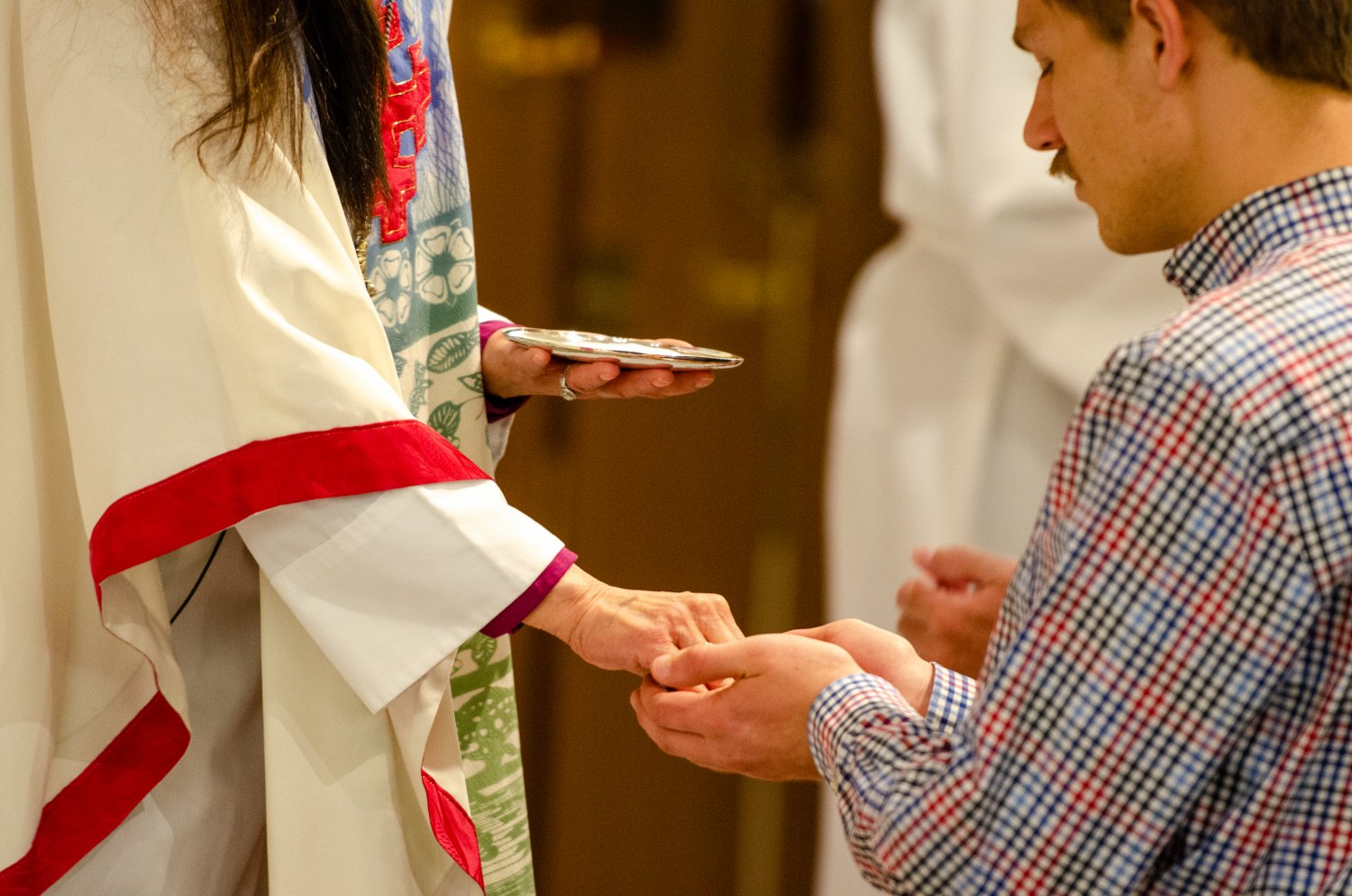 Bishop administering the Eucharist to man