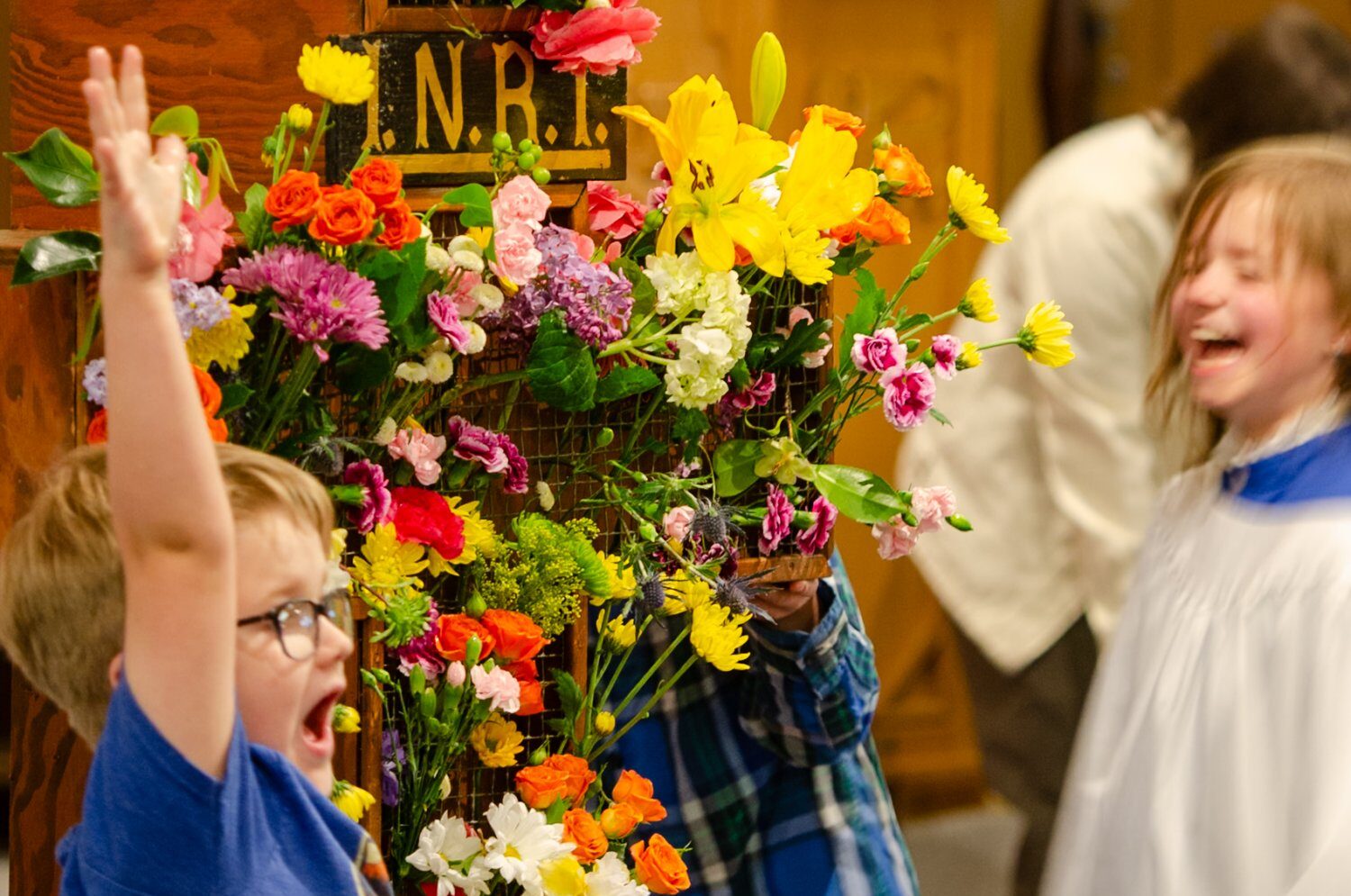 Children laughing while flowering the cross