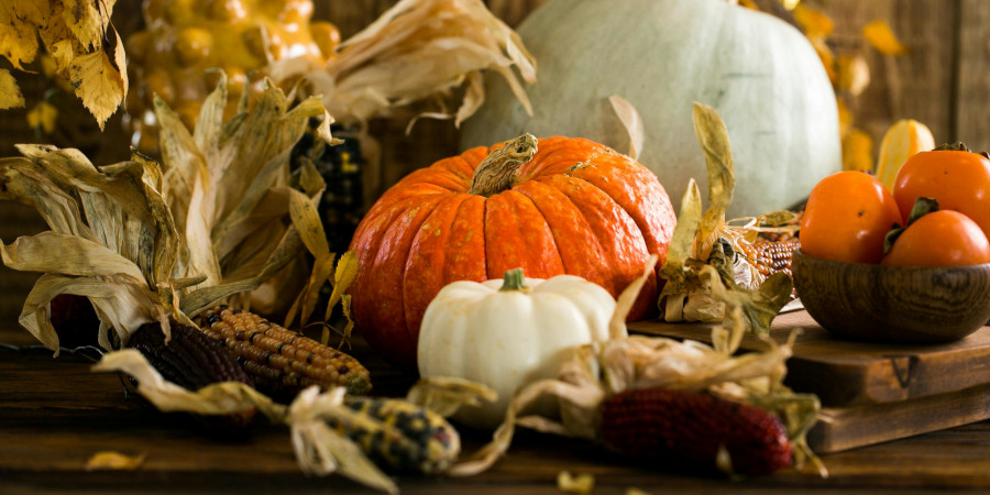 Several pumpkins arranged decoratively with autumn leaves