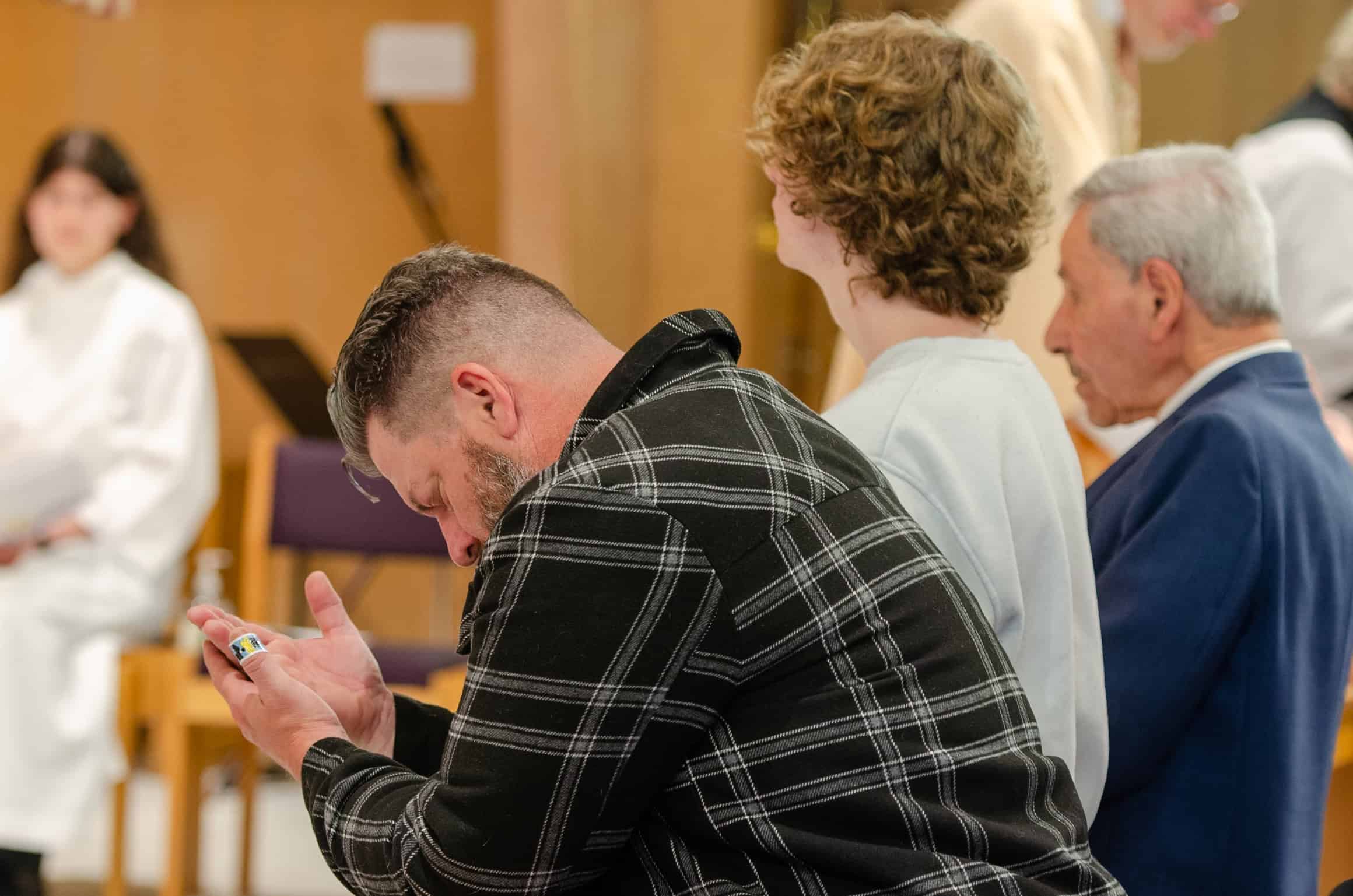 Congregation members praying during a church service at The Episcopal Church of the Good Samaritan.