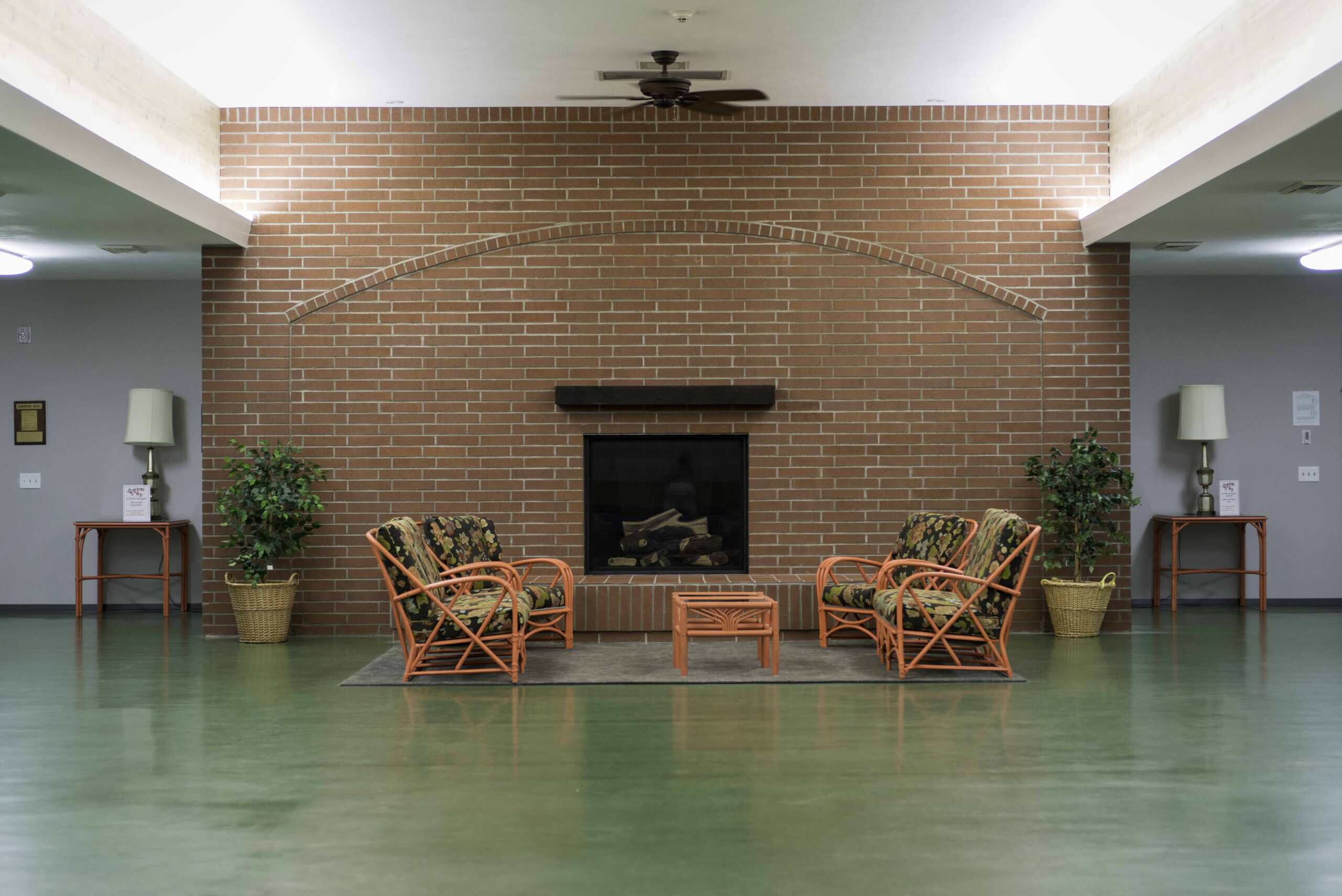 Comfortable seating area with fireplace and potted plants at The Episcopal Church of the Good Samari.