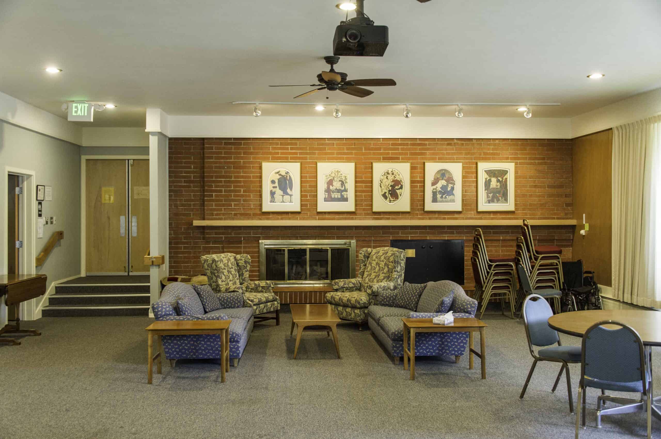 Cozy church lounge with brick wall, artwork, and seating area.
