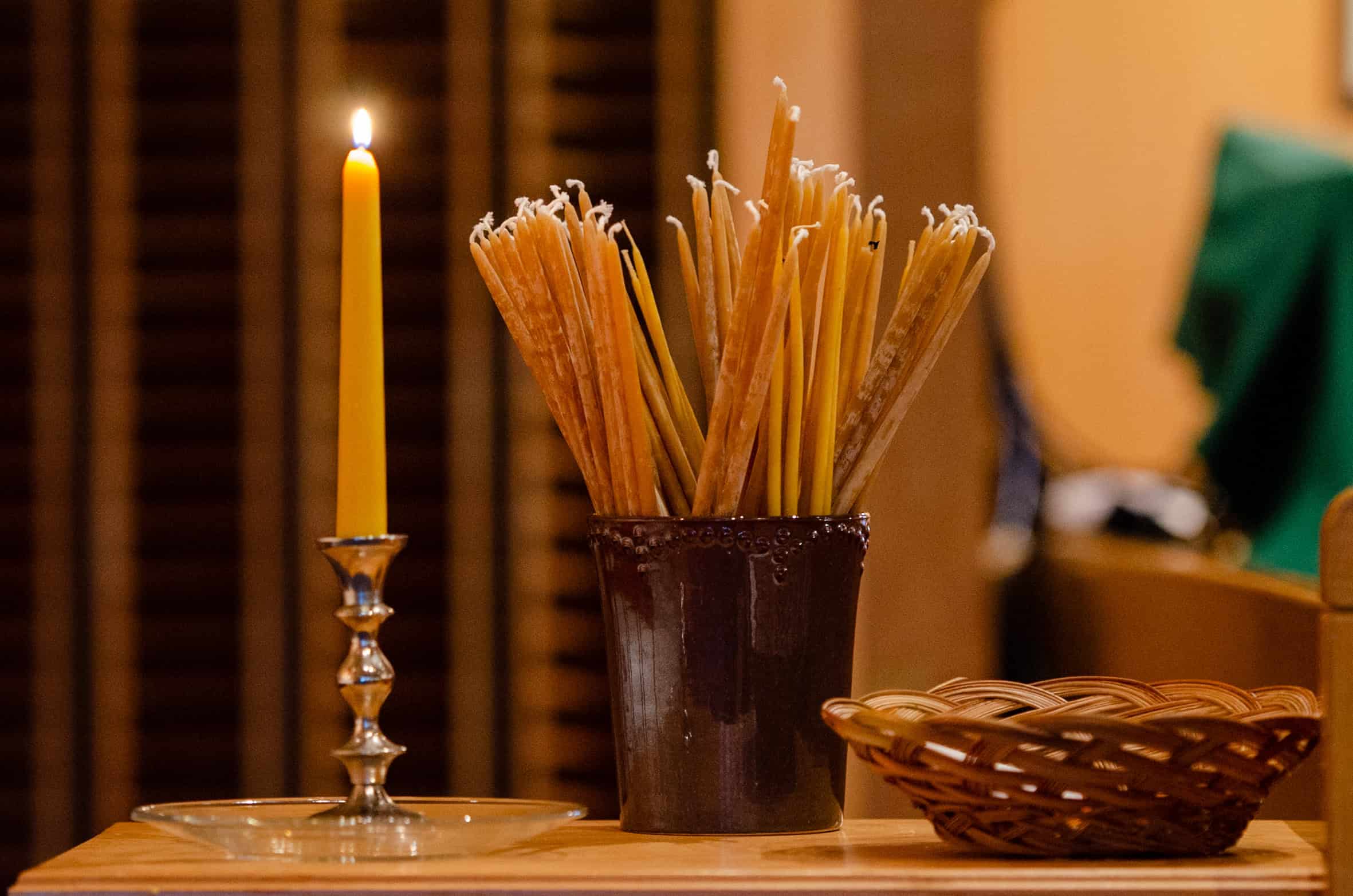 Votive candle and basket of breadsticks on a wooden table at The Episcopal Church of the Good Samar,.