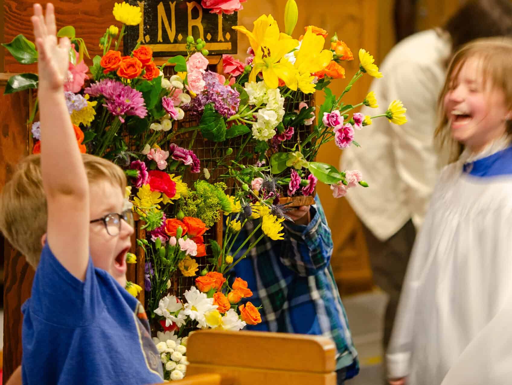 Children celebrating Easter with colorful flowers at The Episcopal Church of the Good Samaritan.