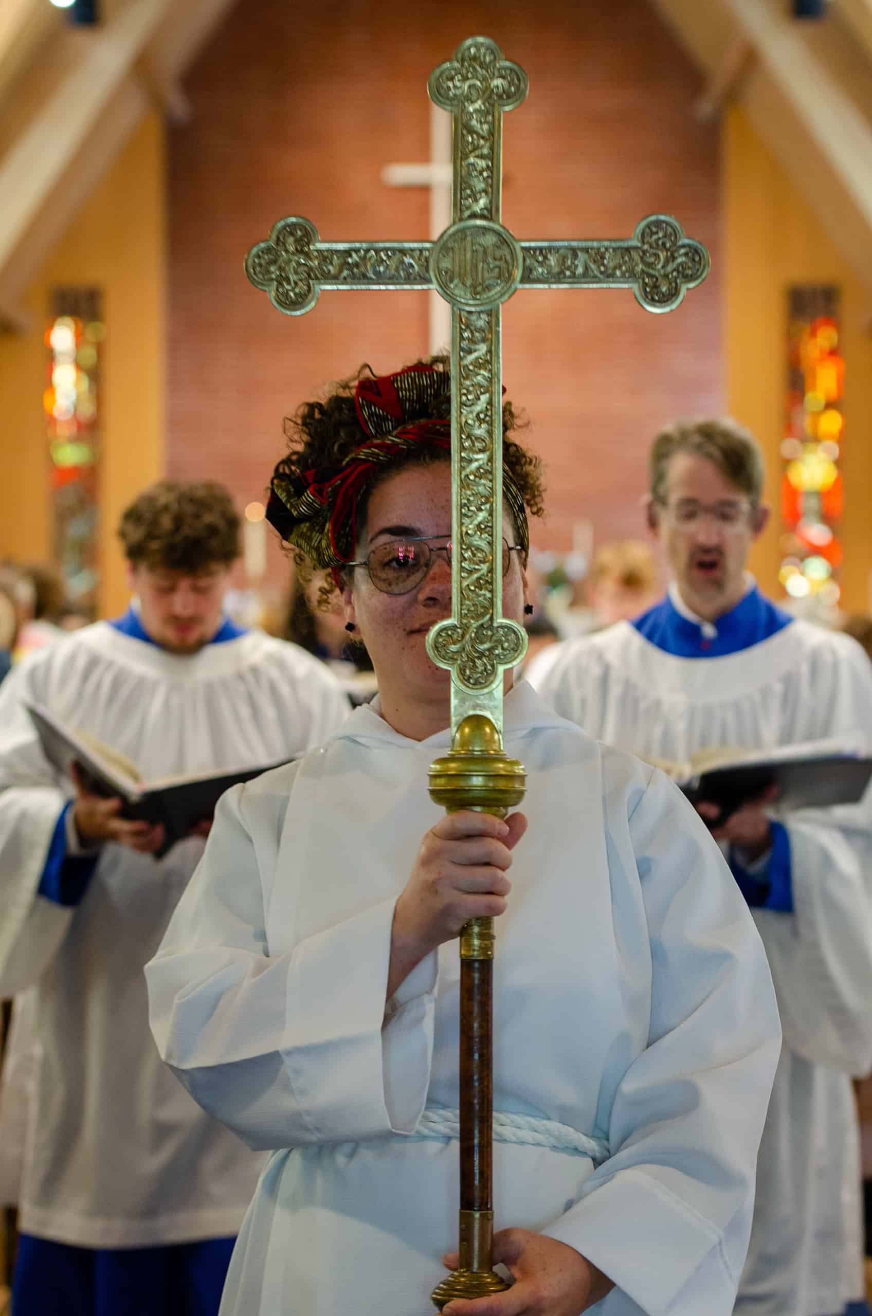 Woman holding a cross during church service at The Episcopal Church of the Good Samaritan.